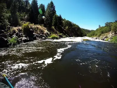 Dark churning water at the entrance of a rapid, seen from a raft